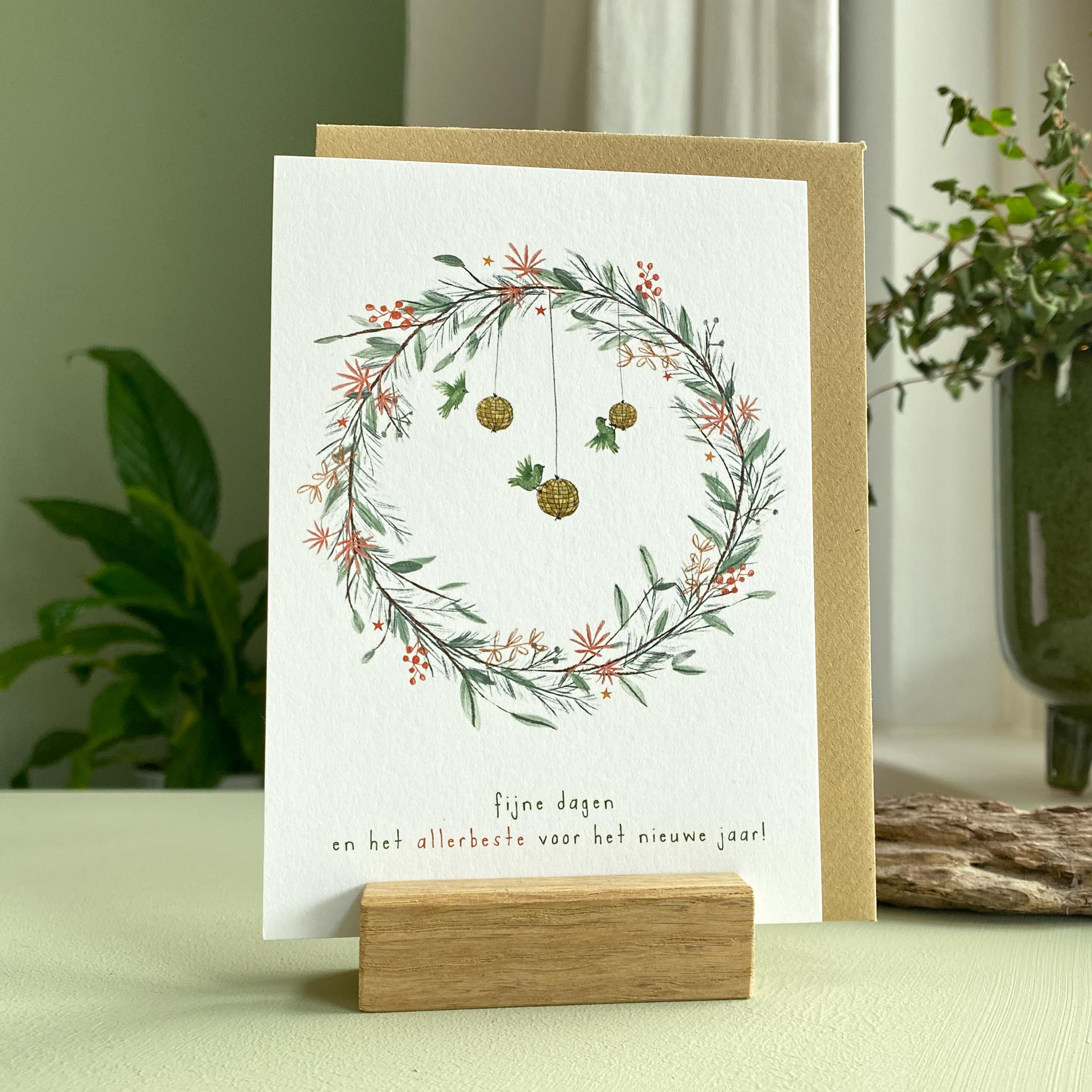 Kerstkaartje winterse krans met besjes en voerbolletjes en vogels